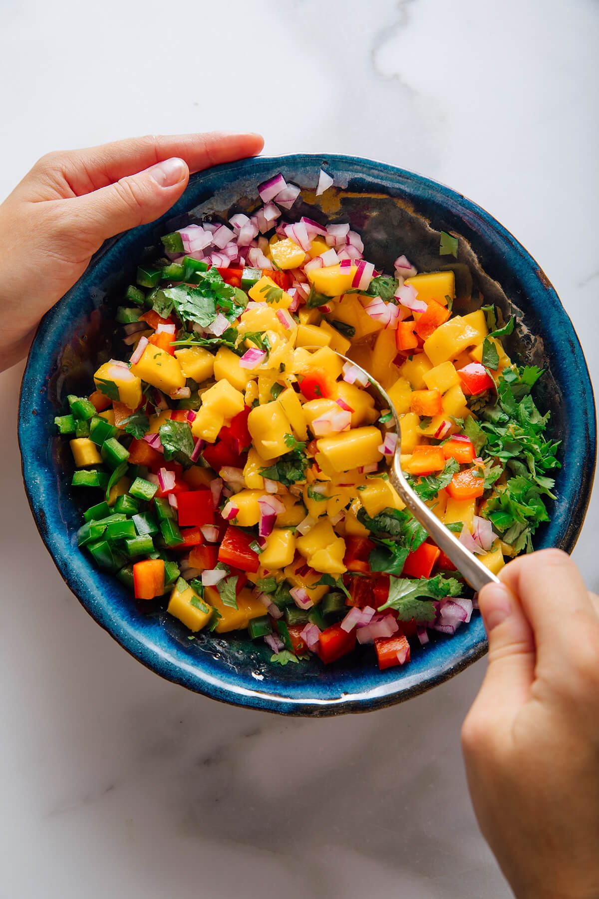 stirring mango salsa